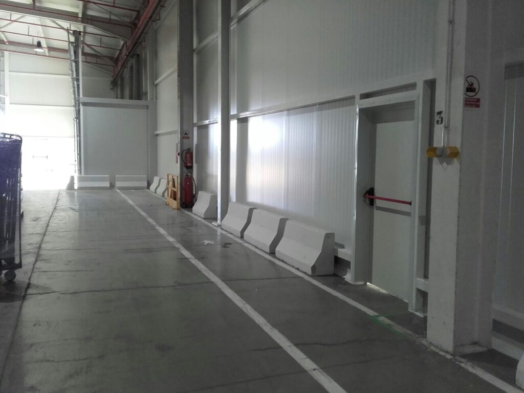 Pasillo interior con divisiones y acabados en panel sandwich.